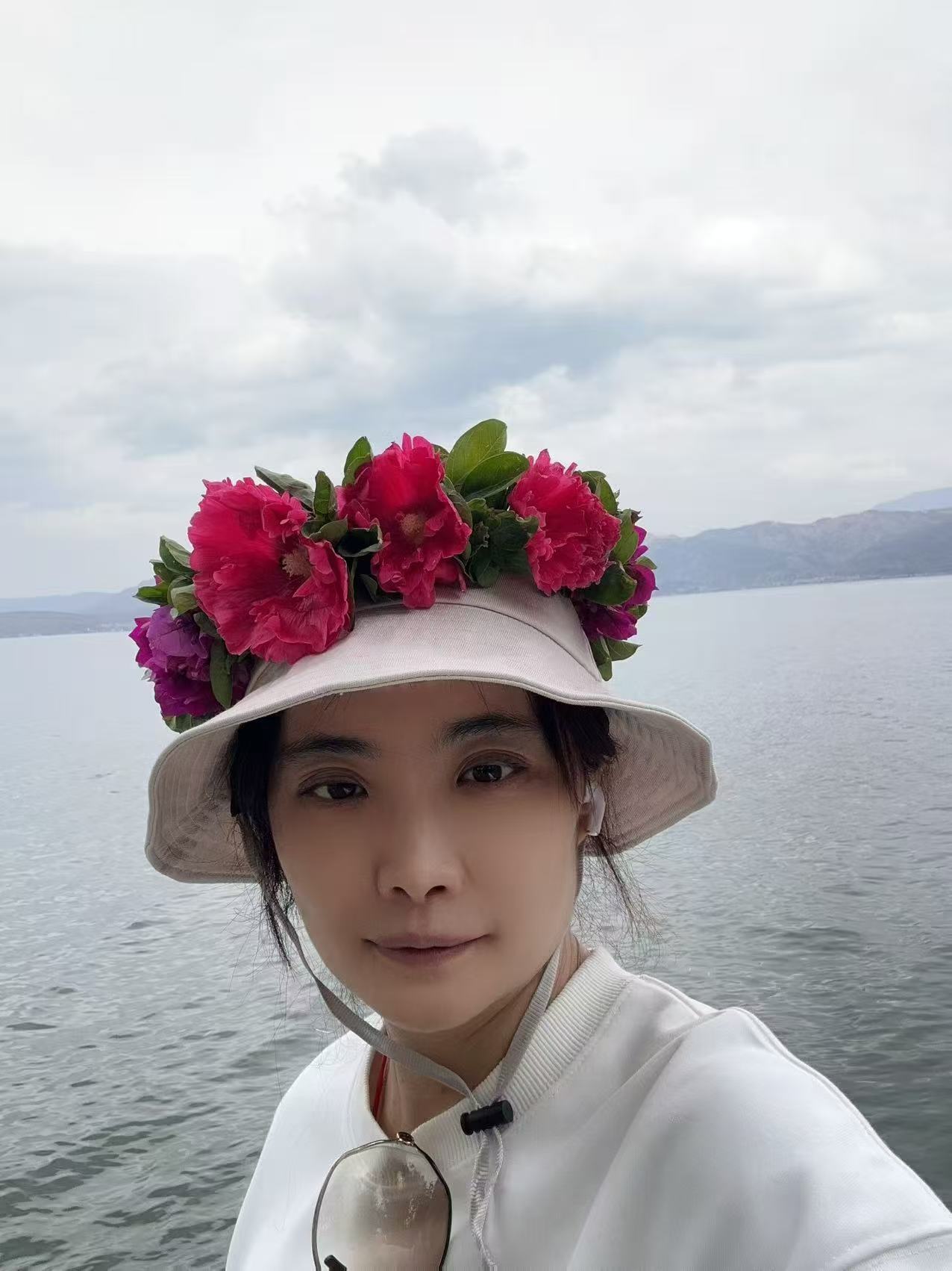 丛从一在湖边，戴着缀满鲜花的帽子
